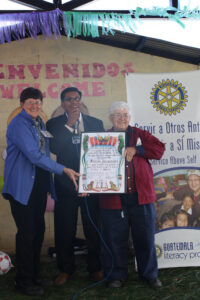 First inauguration at La Camelias school, with donors being presented gift byt school staff on a stage.