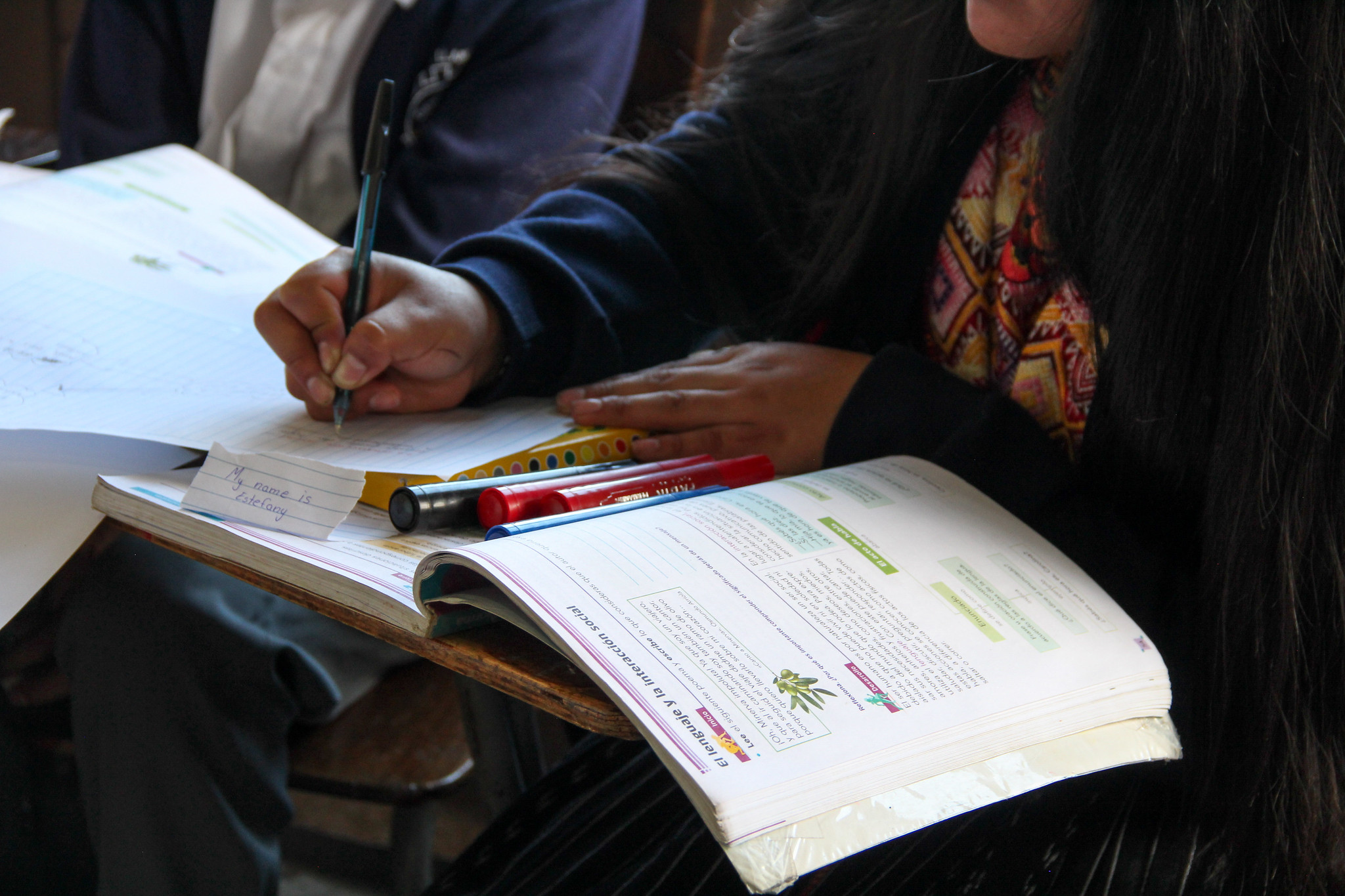 Close-up photo of a student studying using a textbook at their desk.