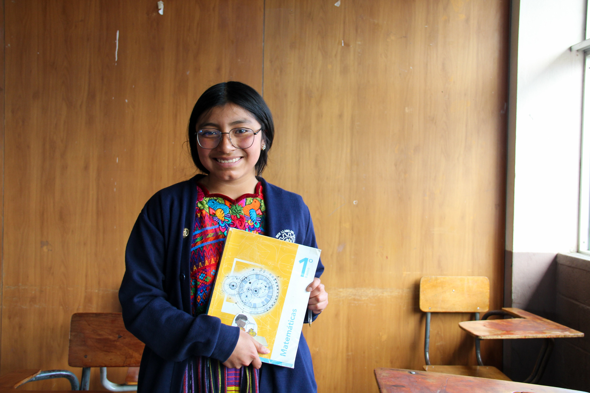 Female Guatemalan student holding textbook