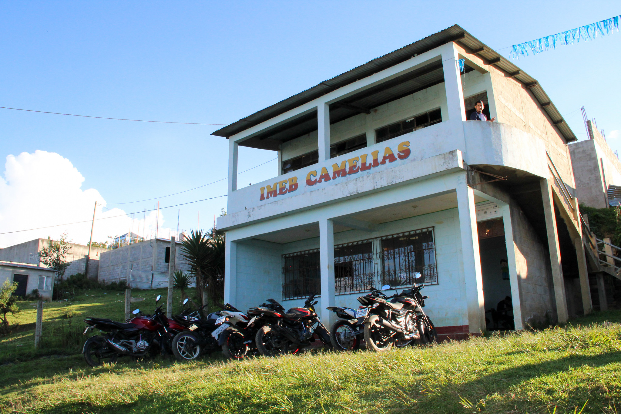 Front of middle school, IMEB Camelias, in rural Guatemala, with moto-bikes lined in front.